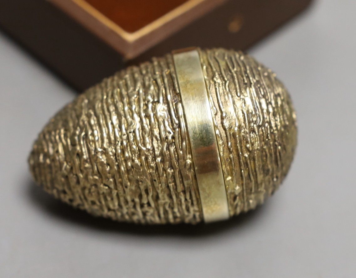 A cased modern silver gilt surprise egg, in the manner of Stuart Devlin, by Richard Lawrence Geere, London, 1976, 67mm, with bust interior.